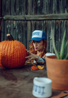 Howdy Pal trucker hat worn outdoors at a Palace Coffee fall event